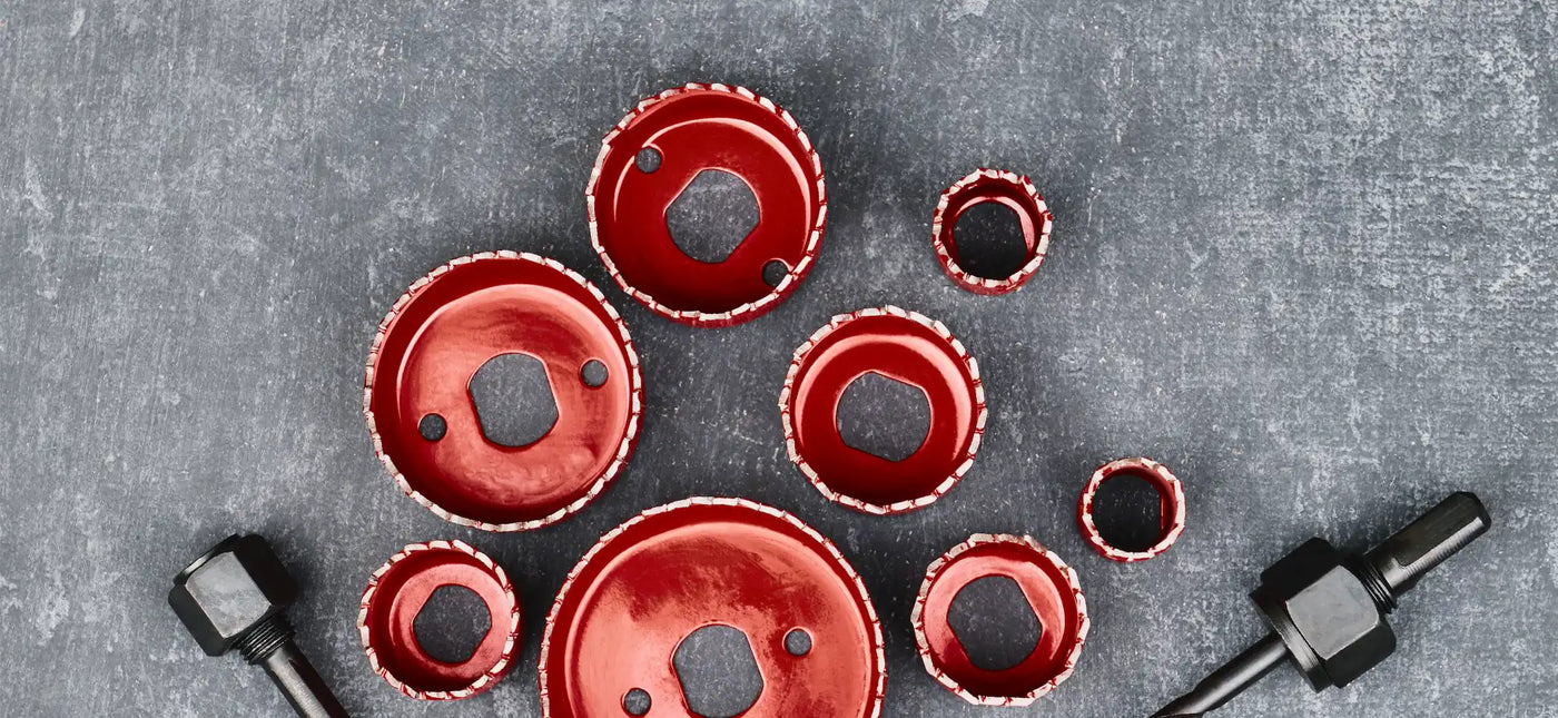 Red circular hole saw drill bits arranged in a pattern.